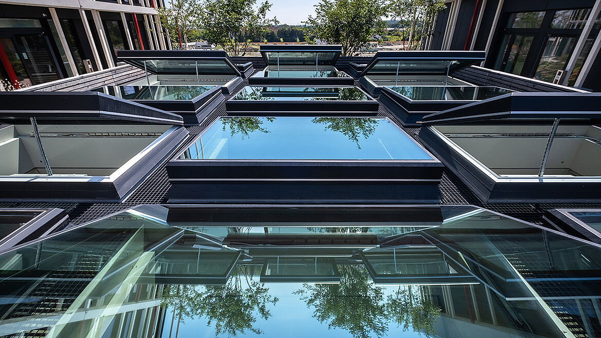 Moderne Glasdachkonstruktion mit mehreren geöffneten Flachdach Fenstern
