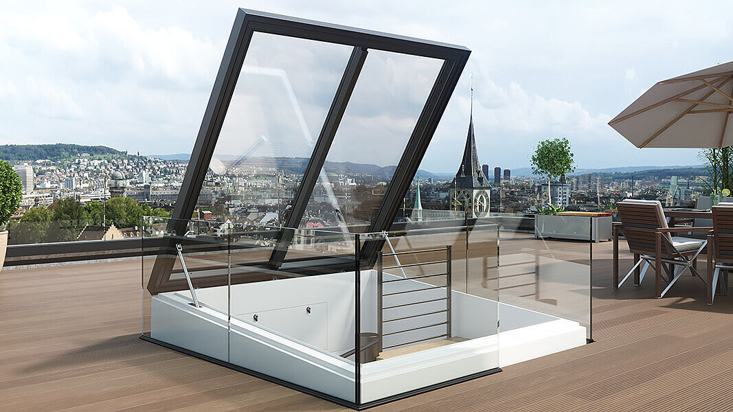 Moderne Dachterrasse mit aufklappbarem Glasdach und Blick auf eine Stadt mit Kirchturm.