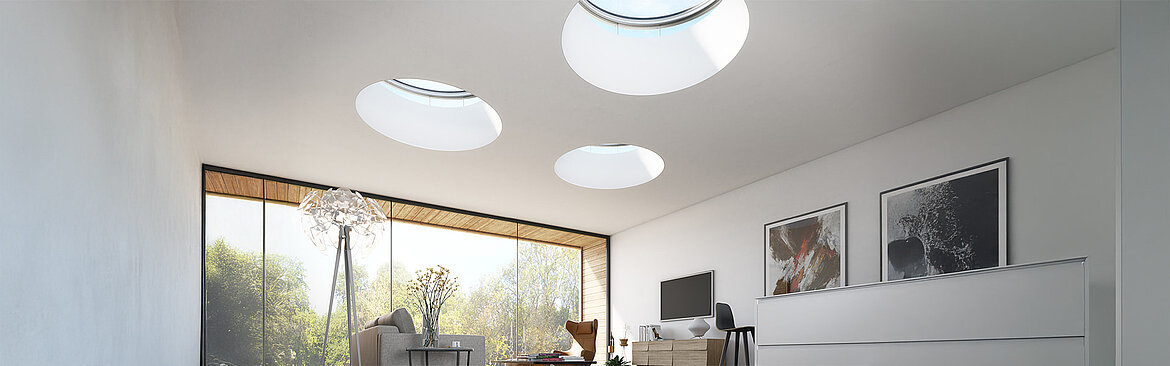 Modernes Wohnzimmer mit runden Lichtkuppeln in der Decke und großer Fensterfront.
